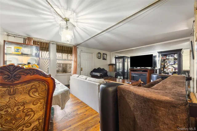 a living room with furniture a flat screen tv and a ceiling fan