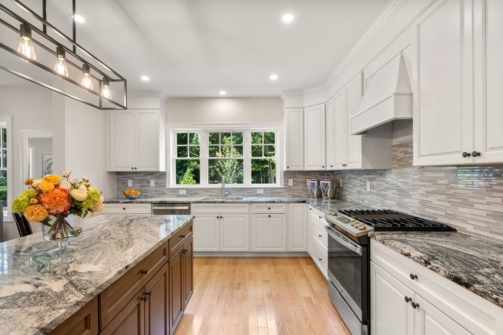 3 Emmeline Path, Unit 3 Wayland, MA 01778 - Photo 5 of 22 a kitchen with stainless steel appliances granite countertop sink stove top oven and cabinets