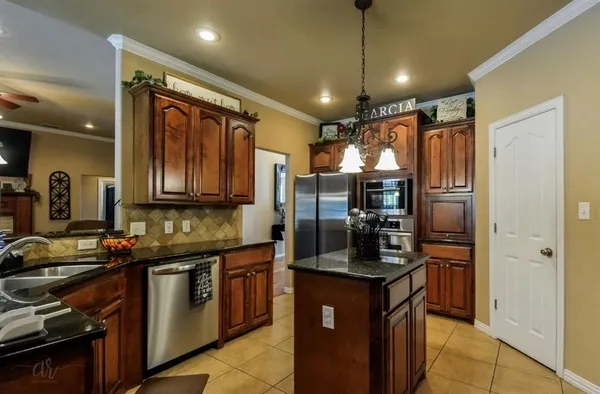 a kitchen with granite countertop stainless steel appliances and wooden cabinets