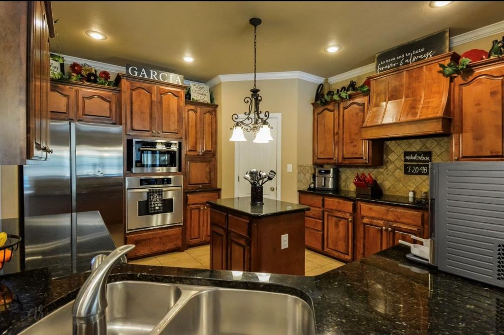 2457 Highway 83 Tuscola, TX 79562 - Photo 13 of 40 a kitchen with stainless steel appliances granite countertop a sink a stove and a refrigerator
