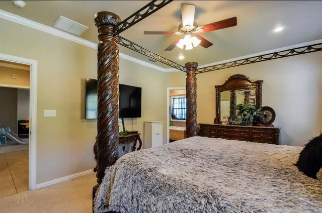 a bedroom with a bed and a mirror on the dresser