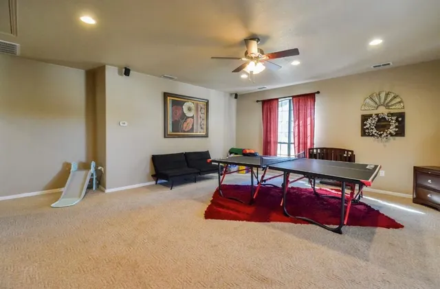 a living room with furniture pool table and window