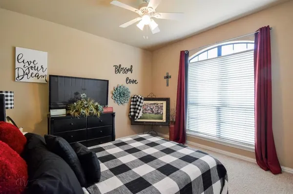 a bedroom with a bed and dresser with mirror