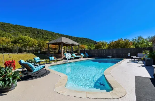 a view of a swimming pool with couches chairs and a fire pit