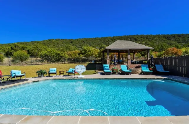 a view of a lake with lawn chairs under an umbrella