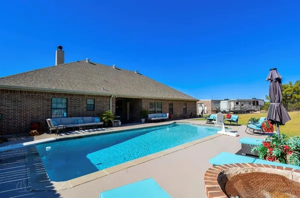 a view of a house with swimming pool and sitting area