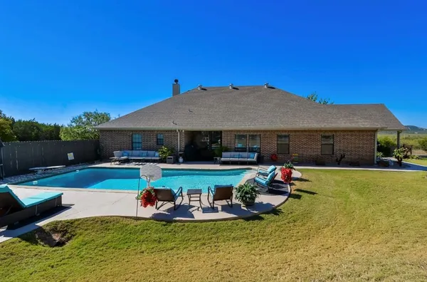 a view of a house with swimming pool and furniture