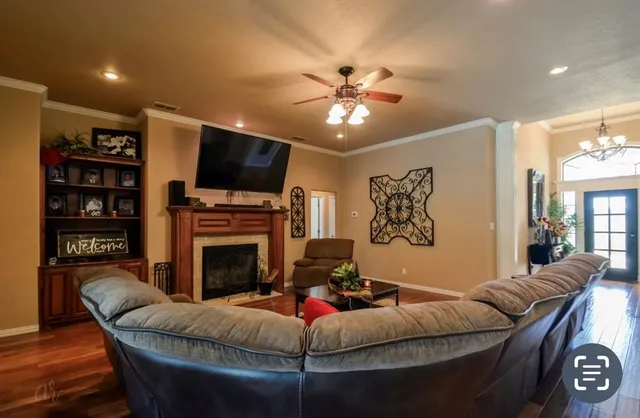 a living room with furniture a flat screen tv and a fireplace