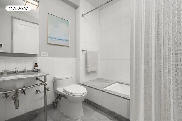 a bathroom with a granite countertop toilet a sink and a mirror