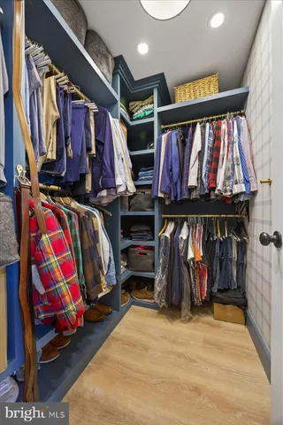 a view of walk in closet with clothes and shoes