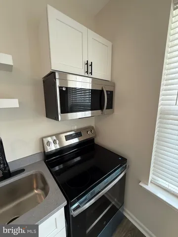 a kitchen with a stove microwave and sink