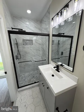 a bathroom with a sink mirror and shower