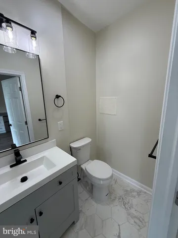a bathroom with a sink a toilet a mirror and vanity