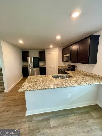 a large kitchen with kitchen island a sink stainless steel appliances and cabinets
