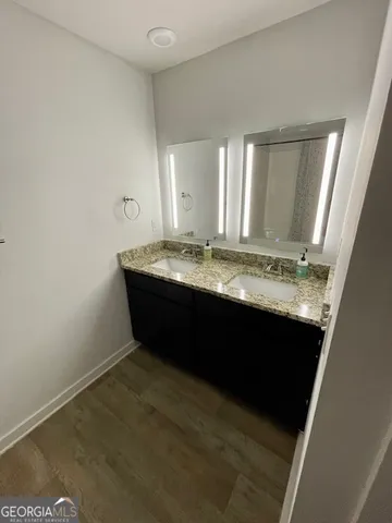 a bathroom with a granite countertop sink and a mirror