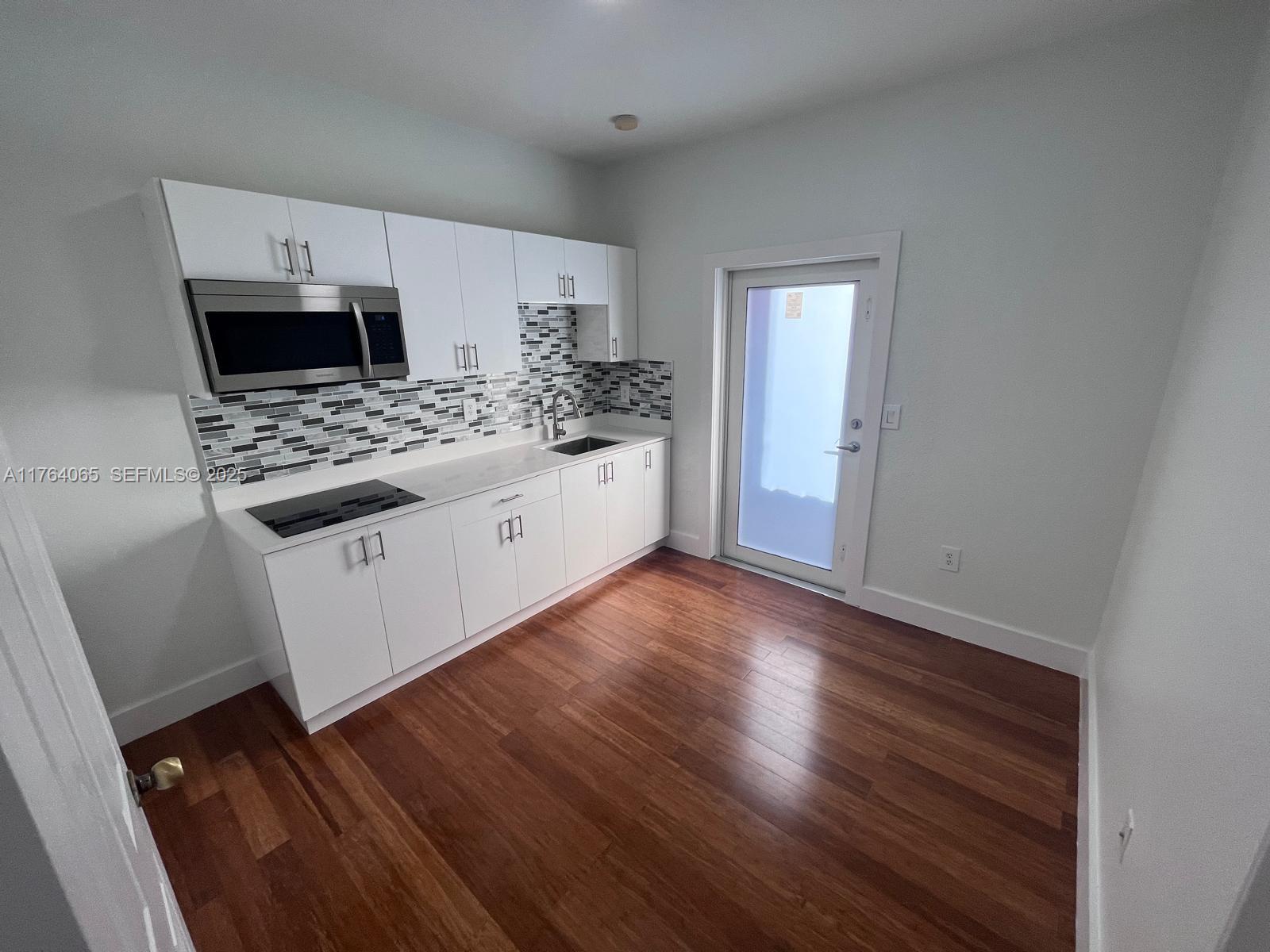 22937 Southwest 9th Avenue, Unit 1 Miami, FL 33170 - Photo 7 of 19 a kitchen with stainless steel appliances a refrigerator sink and microwave