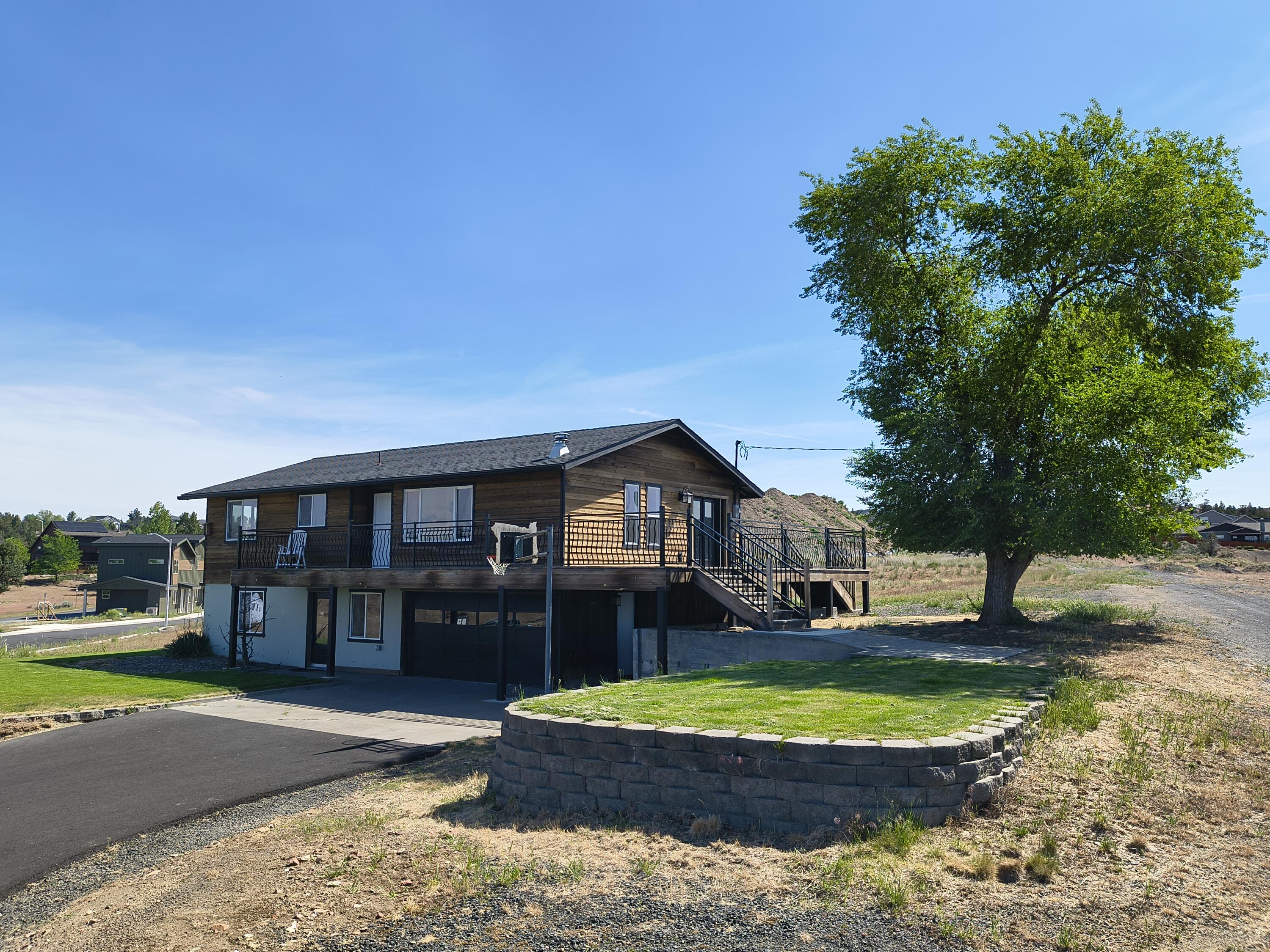 a view of a house with a yard and large trees