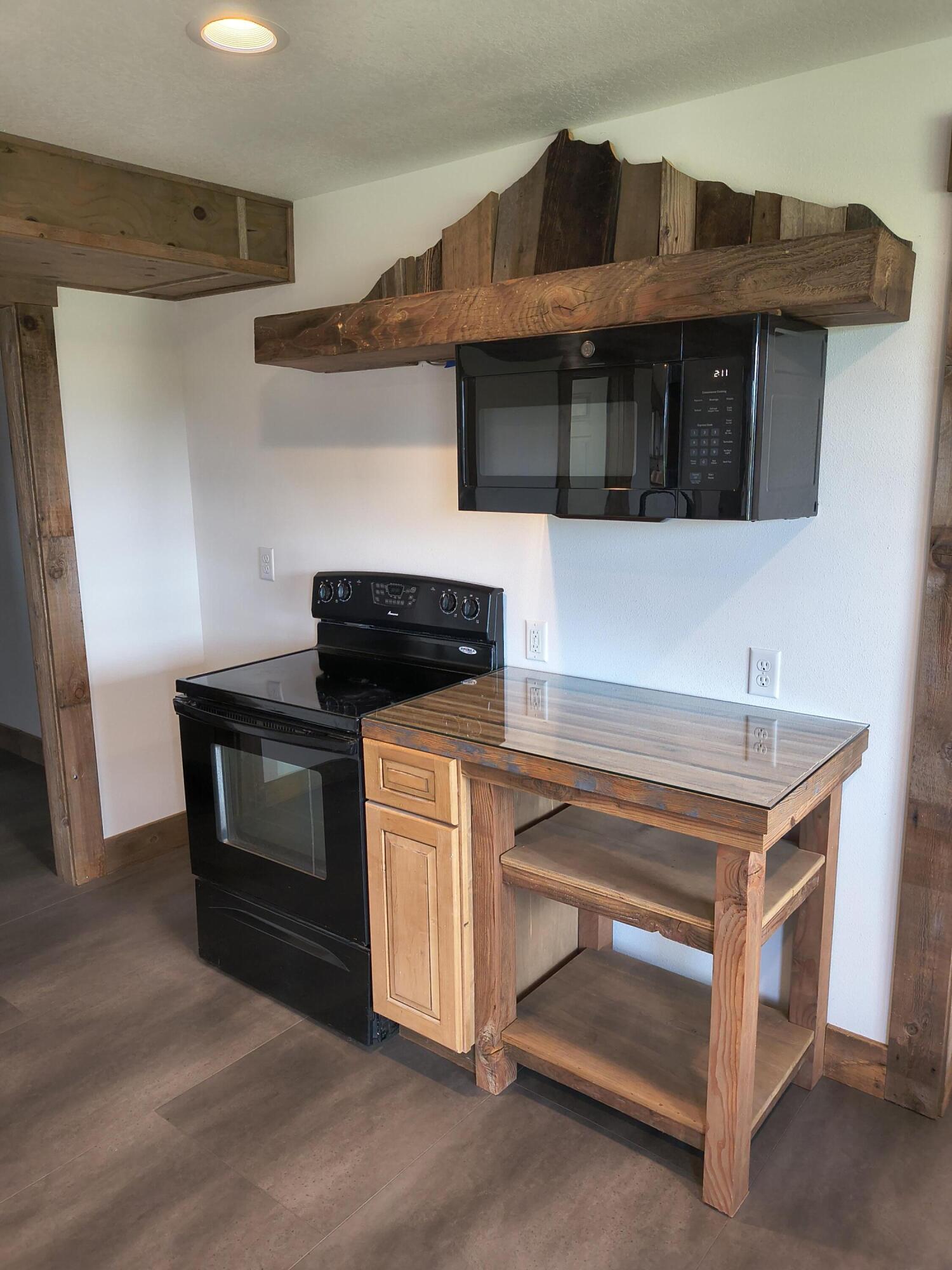 791 Southeast Grizzly Road Madras, OR 97741 - Photo 19 of 31 a kitchen with stainless steel appliances granite countertop a stove and a microwave