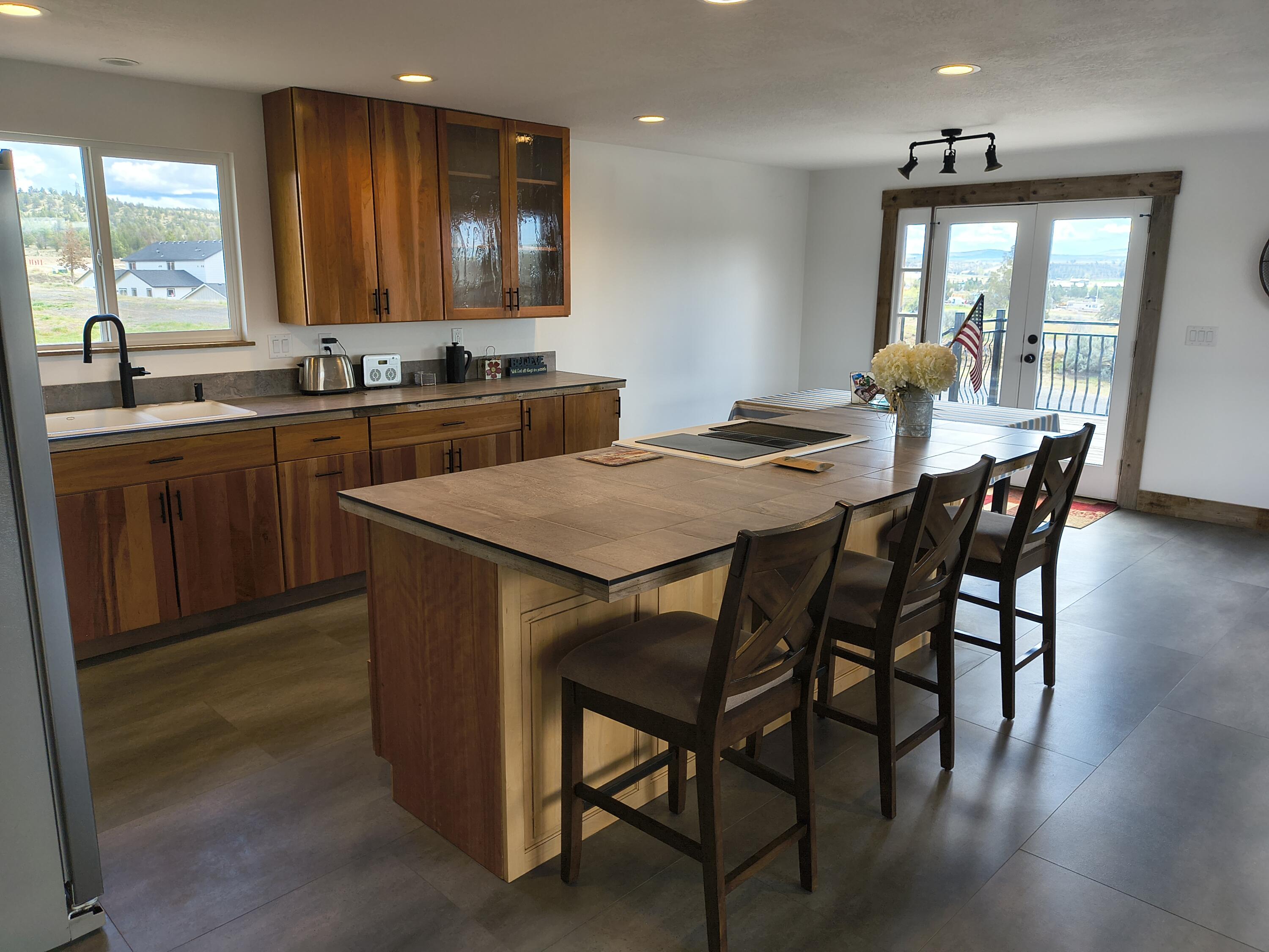 791 Southeast Grizzly Road Madras, OR 97741 - Photo 6 of 31 a kitchen with a table chairs sink and cabinets
