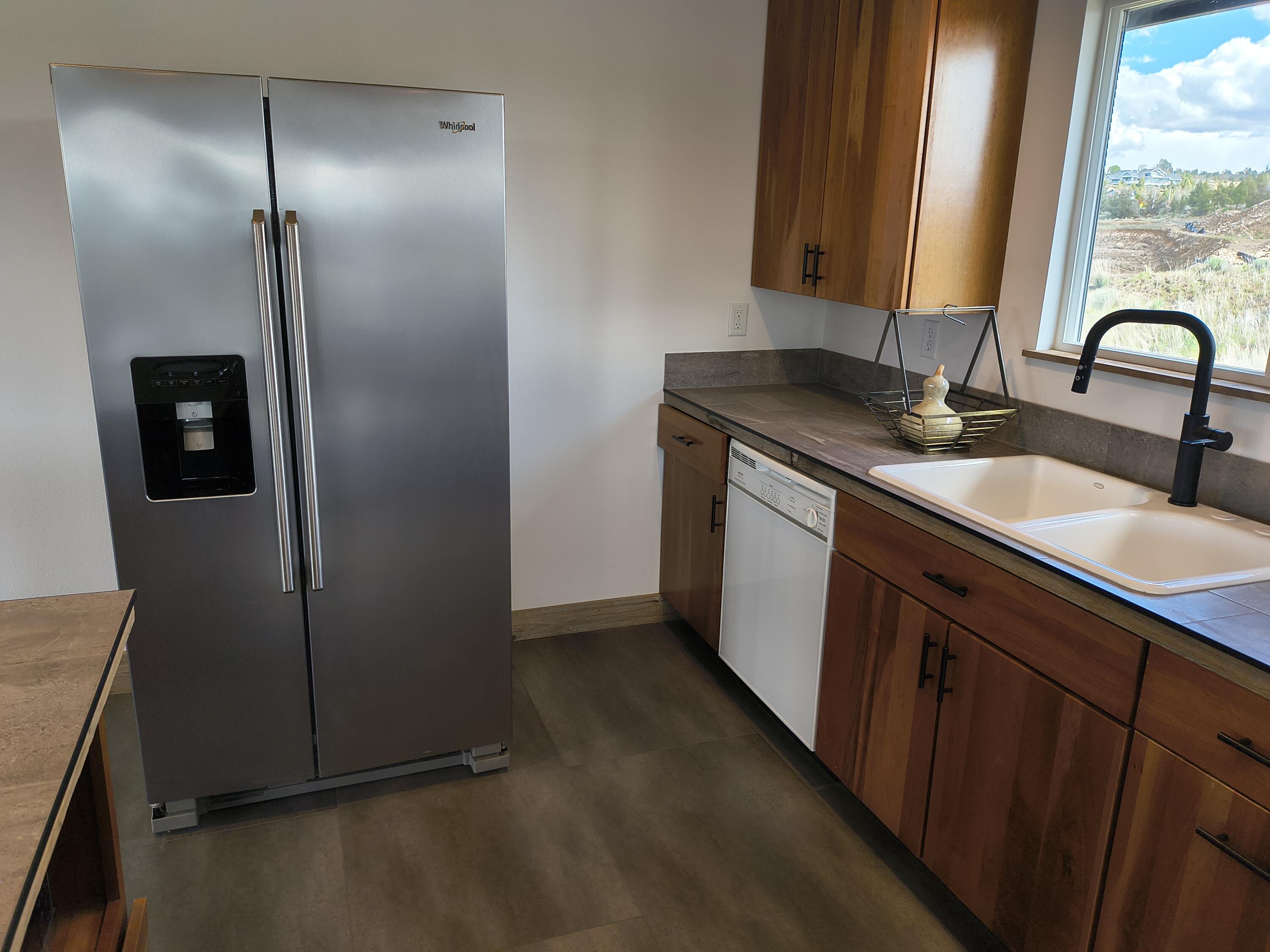 791 Southeast Grizzly Road Madras, OR 97741 - Photo 8 of 31 a kitchen with stainless steel appliances granite countertop a sink and a refrigerator
