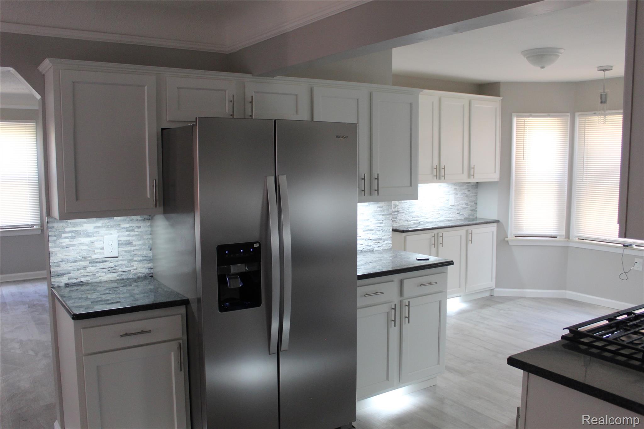 5543 Balfour Road Detroit, MI 48224 - Photo 54 of 54 Modern kitchen featuring white shaker cabinetry with brushed nickel hardware, dark countertops, and a full-size stainless steel refrigerator