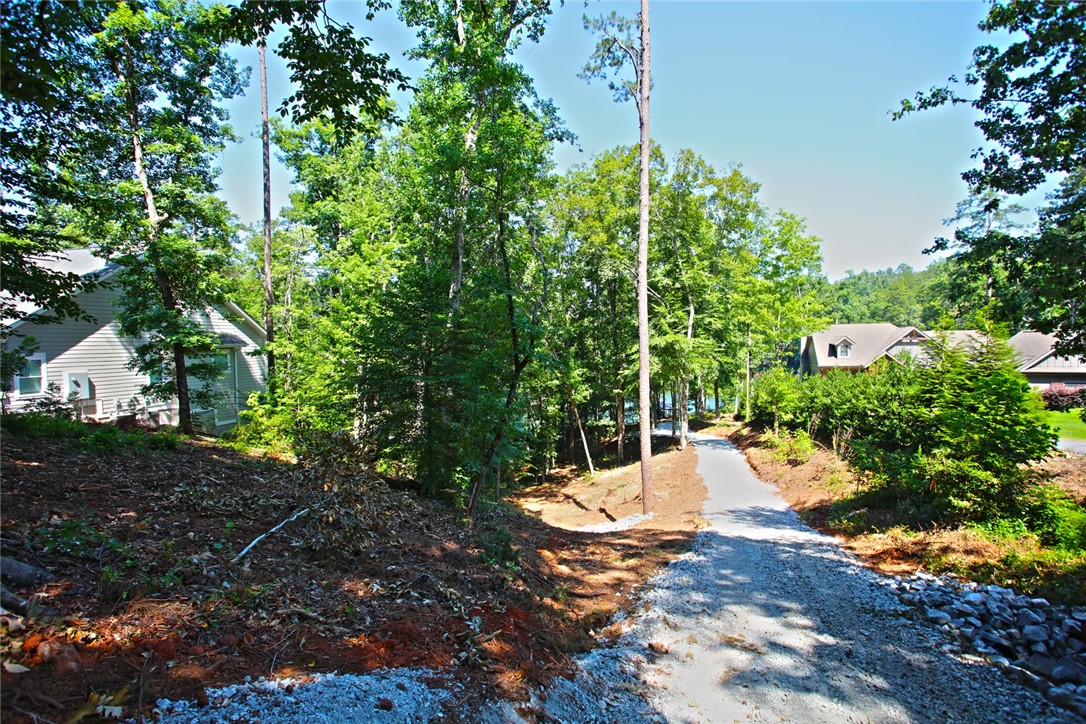 1359 Hbr Rdg Road Seneca, SC 29672 - Photo 9 of 39 A tranquil path leads through lush woods to a serene lakeside community.