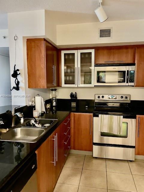 3232 Southwest 22nd Terrace, Unit 1303 Miami, FL 33145 - Photo 7 of 43 a kitchen with stainless steel appliances a stove a sink and a microwave