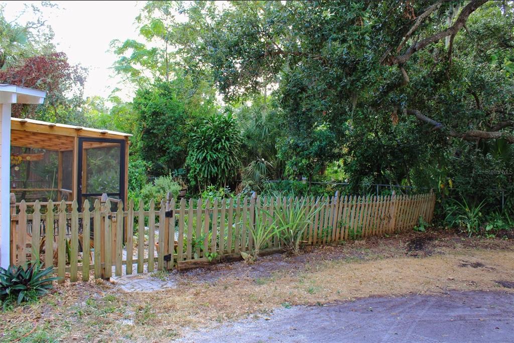 4225 Bradenton Road, Unit C Sarasota, FL 34234 - Photo 19 of 19 a view of a backyard with wooden fence and a large tree