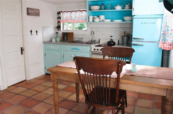 a kitchen with a table chairs and a refrigerator