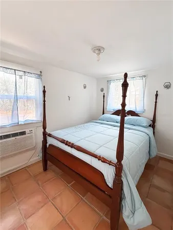 a bedroom with a bed and a large window
