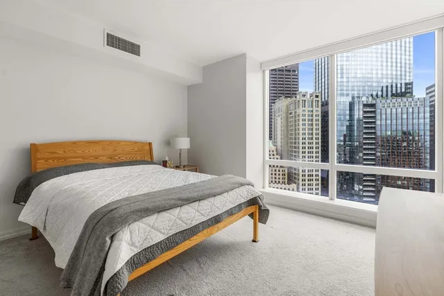 a bedroom with a bed and a large window