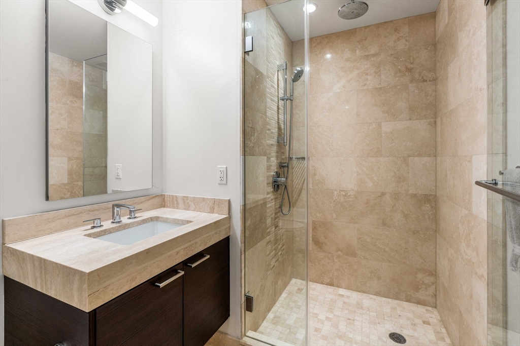 1 Franklin Street, Unit 2609 Boston, MA 02110 - Photo 16 of 24 a bathroom with a sink vanity granite shower and a mirror