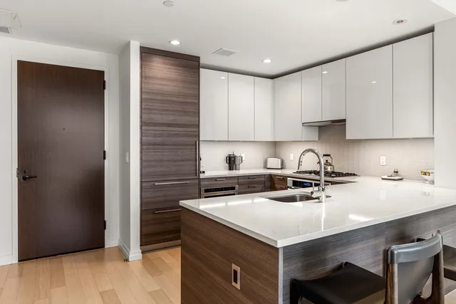 a kitchen with a stove sink and cabinets