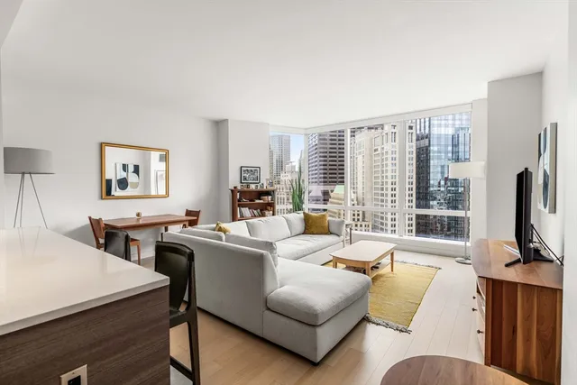 a living room with furniture flat screen tv and a large window