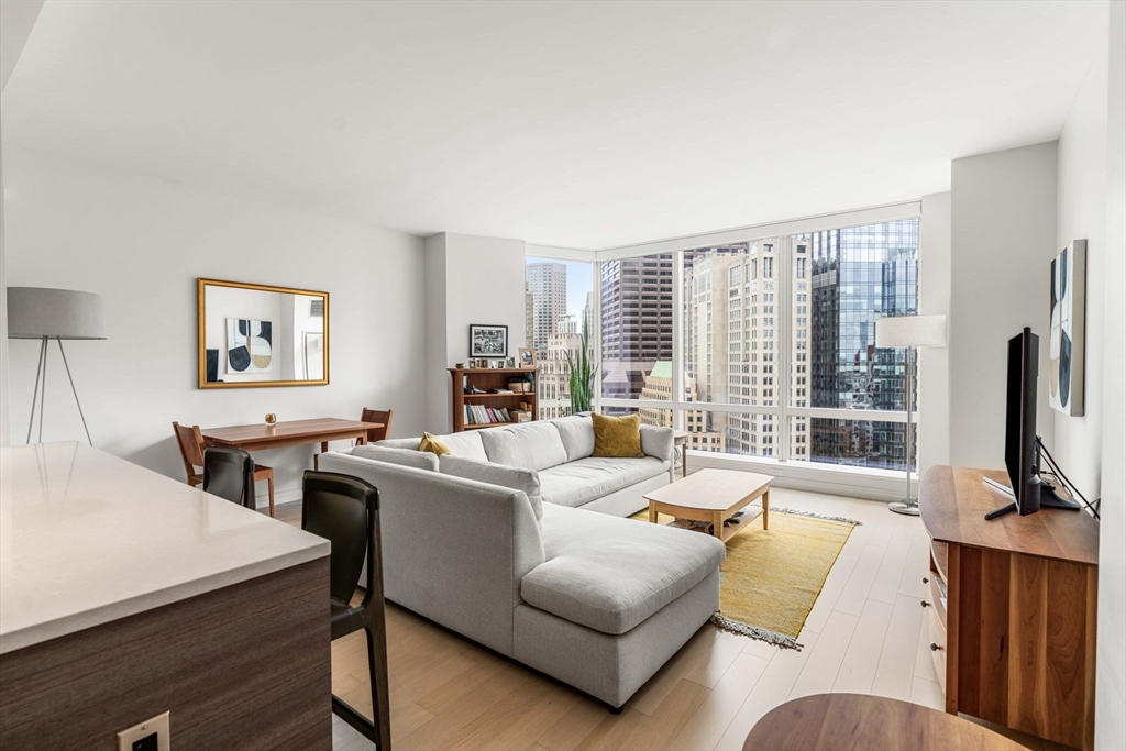 1 Franklin Street, Unit 2609 Boston, MA 02110 - Photo 10 of 24 a living room with furniture flat screen tv and a large window