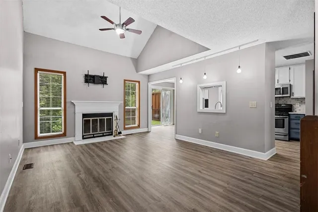 a view of a livingroom with wooden floor and a fireplace