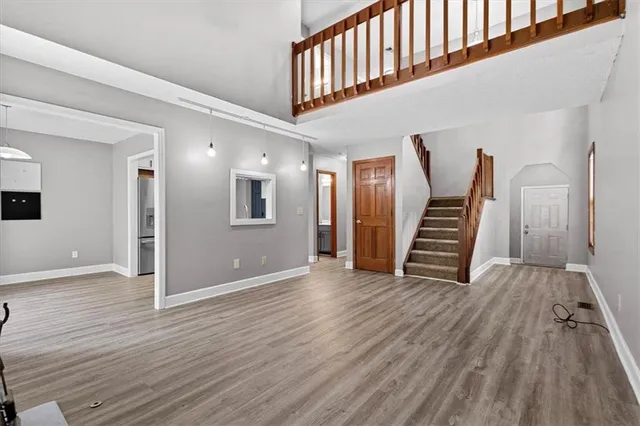 a view of a hallway with wooden floor and staircase