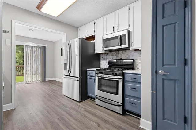 a kitchen with granite countertop a refrigerator and a stove top oven