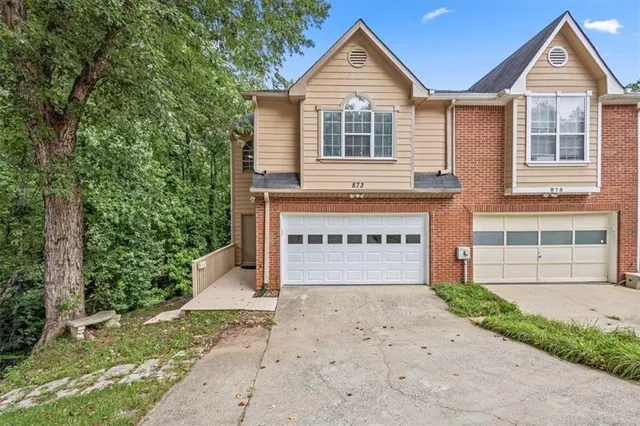 a front view of a house with a yard and garage