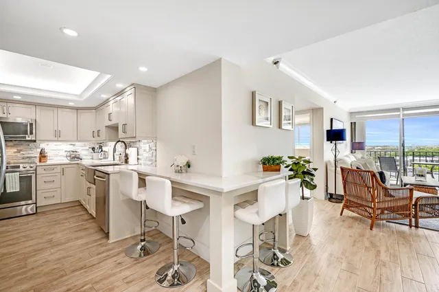 a kitchen with a dining table chairs and view living room