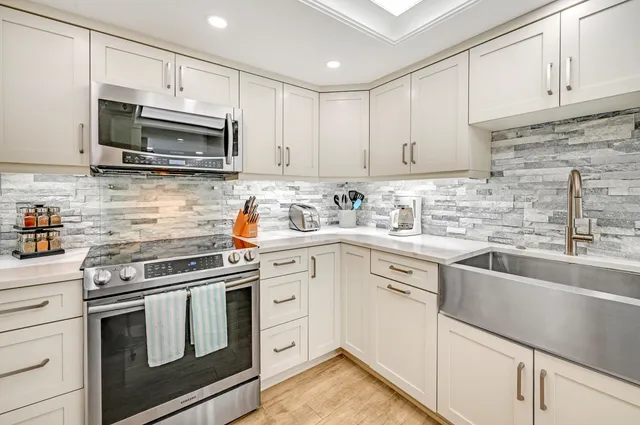 a kitchen with white cabinets stainless steel appliances and sink