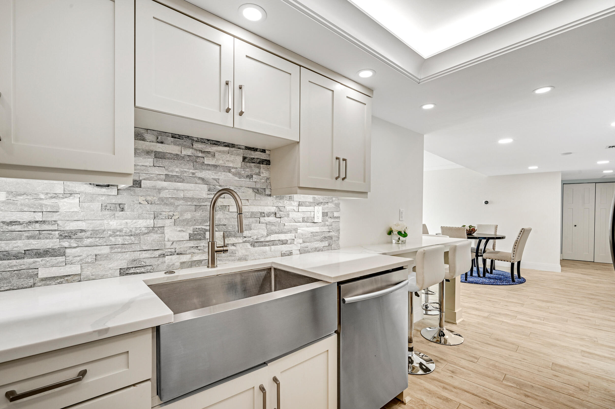 1300 Florida A1A, Unit 624 Jupiter, FL 33477 - Photo 10 of 35 a kitchen with stainless steel appliances a sink a stove and white cabinets with wooden floor