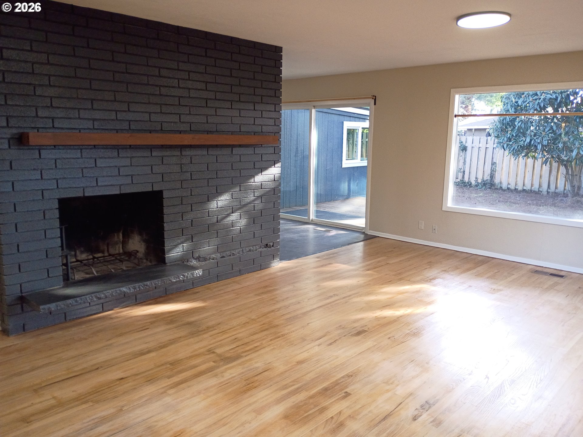 625 North Knights Bridge Road Canby, OR 97013 - Photo 3 of 18 a view of empty room with wooden floor and fireplace