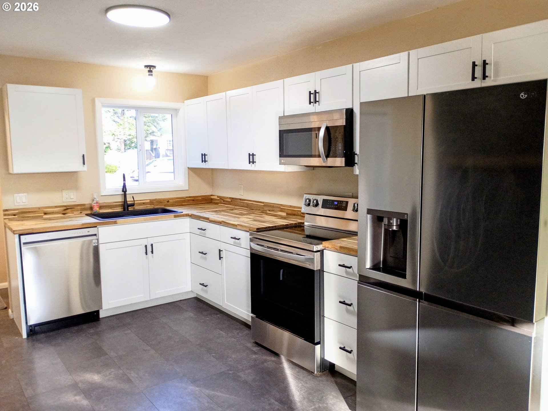 625 North Knights Bridge Road Canby, OR 97013 - Photo 6 of 18 a kitchen with white cabinets and stainless steel appliances