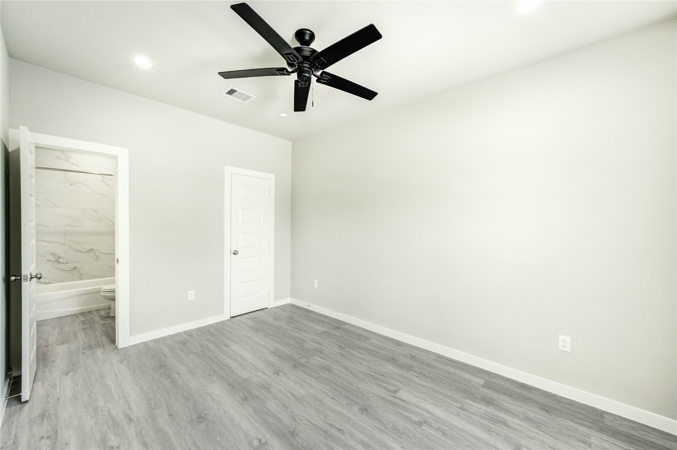 8157 Tate Street, Unit A Houston, TX 77028 - Photo 15 of 29 an empty room with wooden floor and a ceiling fan