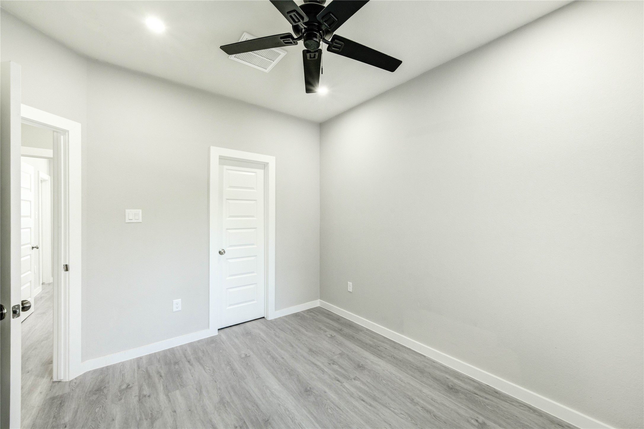8157 Tate Street, Unit A Houston, TX 77028 - Photo 21 of 29 an empty room with a ceiling fan and wooden floor