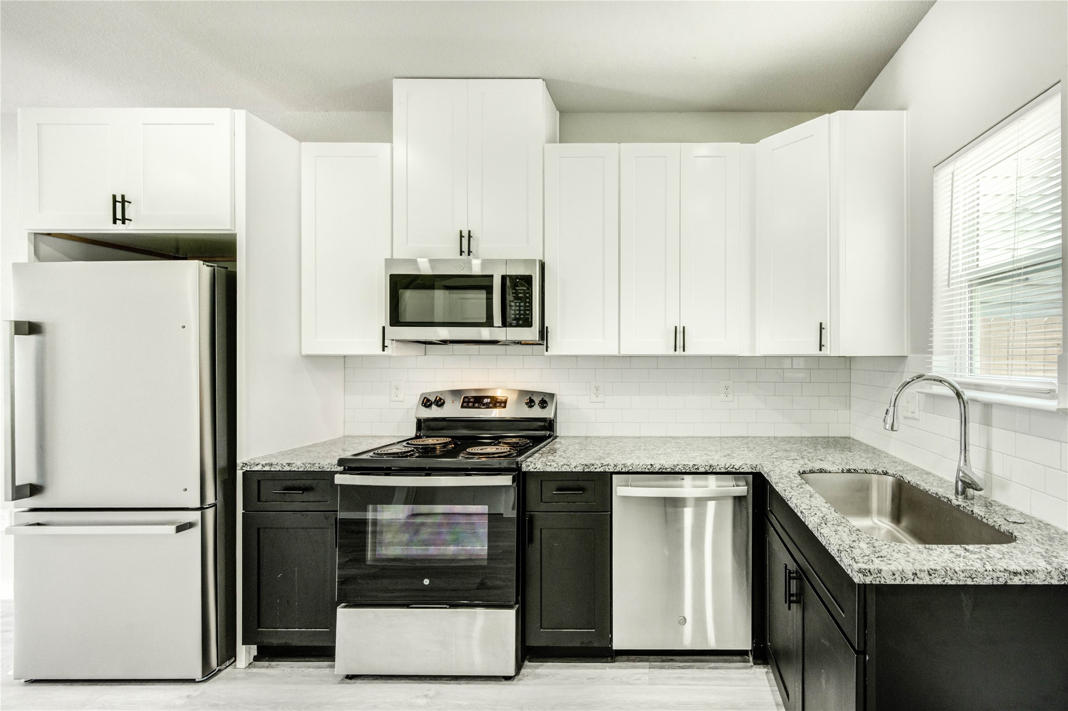 8157 Tate Street, Unit A Houston, TX 77028 - Photo 5 of 29 a kitchen with granite countertop a sink stove and refrigerator