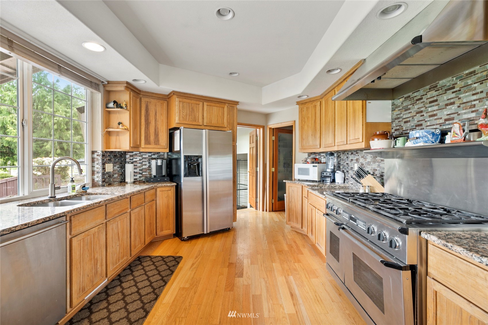 300 West Elk Ridge Road Shelton, WA 98584 - Photo 11 of 40 a kitchen with stainless steel appliances granite countertop a stove a sink dishwasher a refrigerator and wooden cabinets with wooden floor