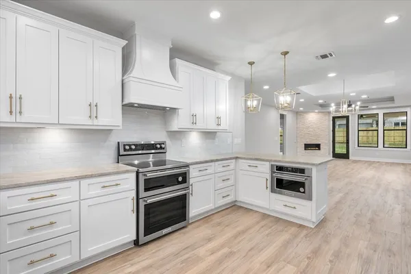 a kitchen with granite countertop a stove a sink and a refrigerator