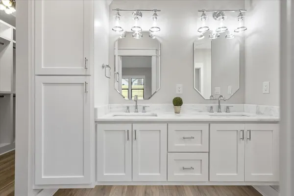 a bathroom with double vanity sinks and a mirror